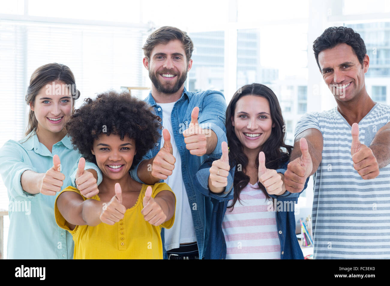 Creative business people gesturing thumbs up by blackboard Stock Photo ...