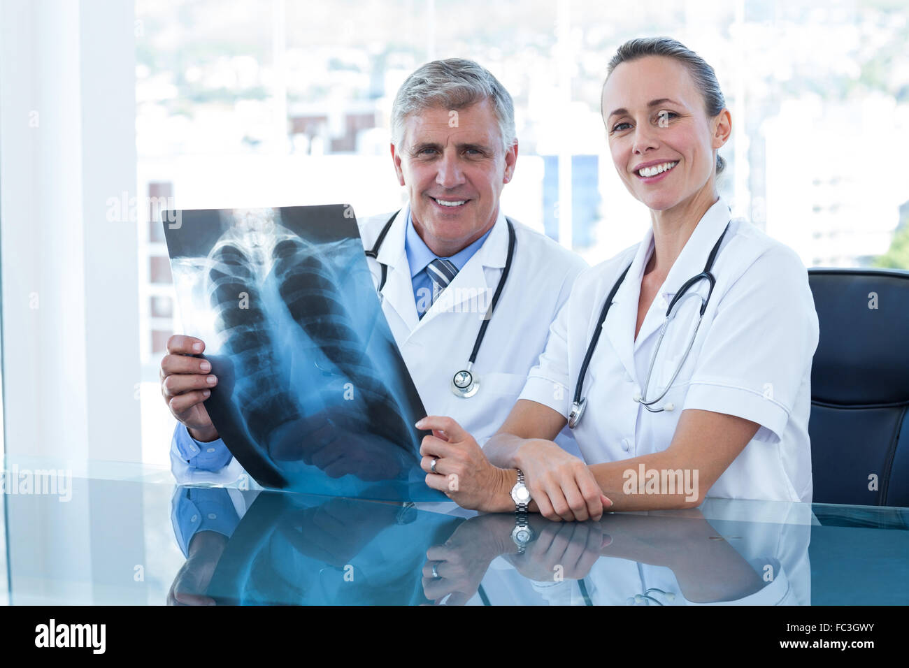 Doctor looking xray smiling camera hi-res stock photography and images ...