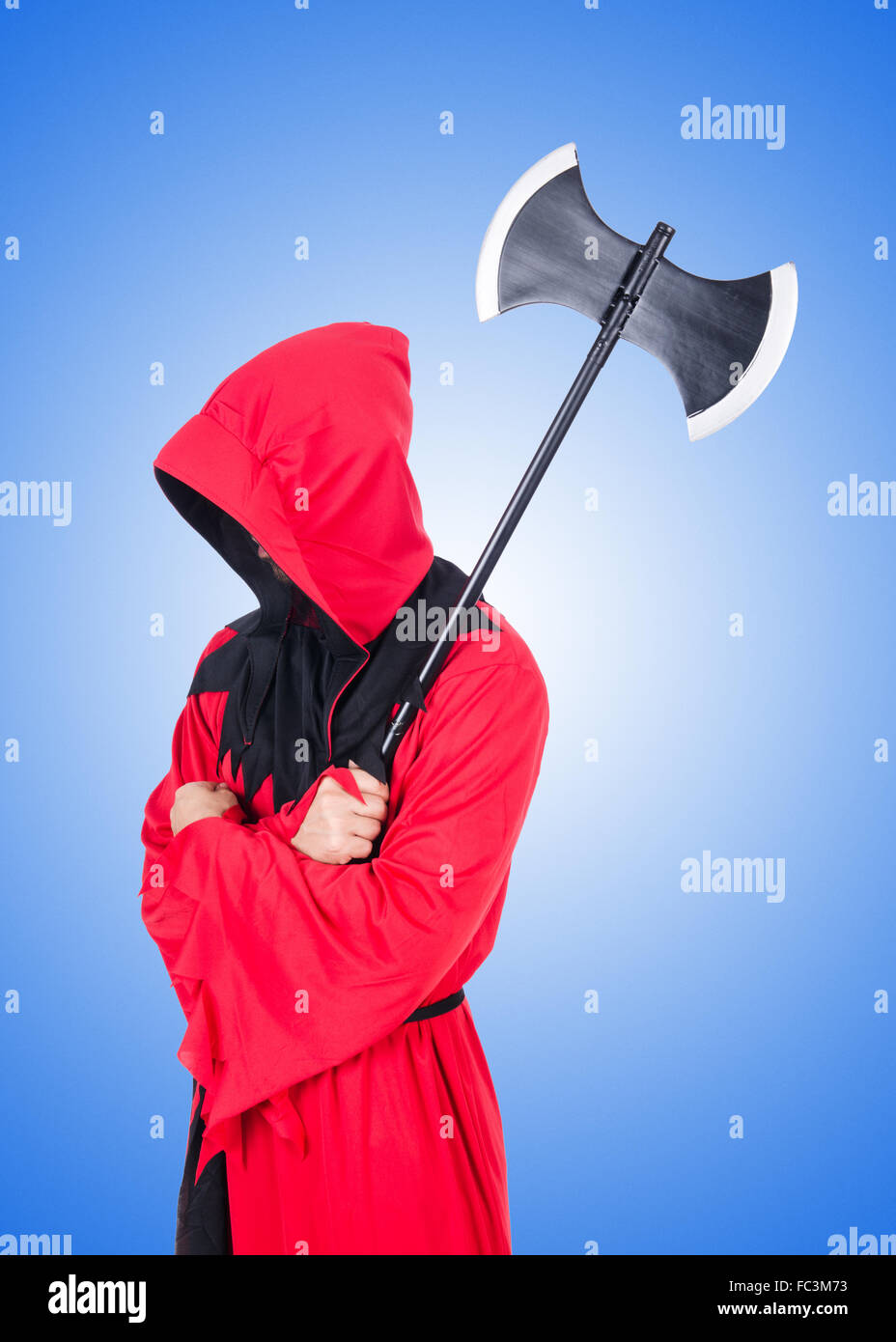 Executioner in red costume with axe against the gradient Stock Photo