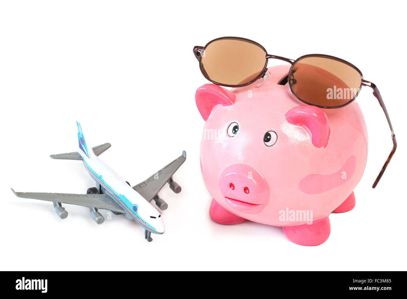 Piggy bank with sunglasses and toy plane Stock Photo