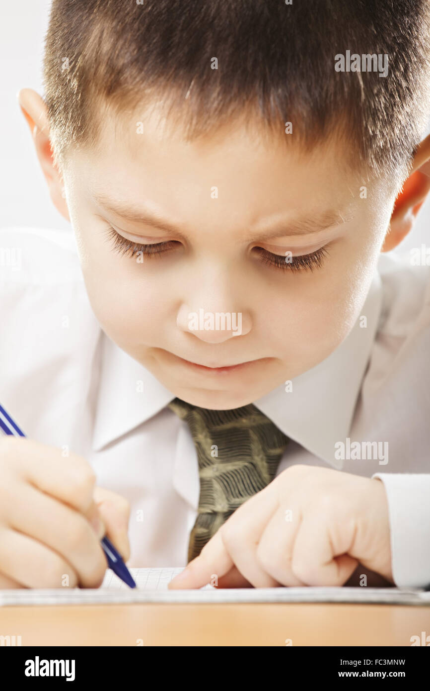 Concentrated caucasian boy writing closeup Stock Photo