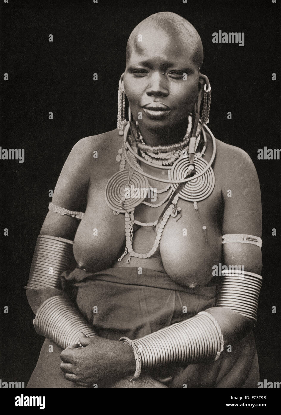 Adornment Custom.  A married, or about to be married Masai girl adorned with coils of thick iron wire around her limbs.  The removal of eyelashes and eyebrow hair was also a general custom.  After a 19th century photograph. Stock Photo