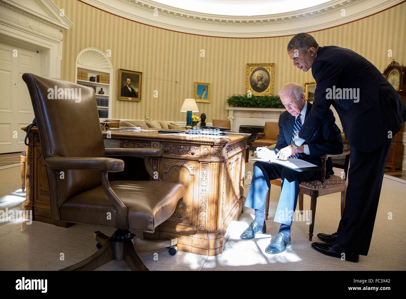 U.S President Barack Obama reviews a statement with Vice President Joe Biden in the Oval Office of the White House October 21, 2015 in Washington, DC. The statement was Biden's announcement not to seek the presidency. Stock Photo