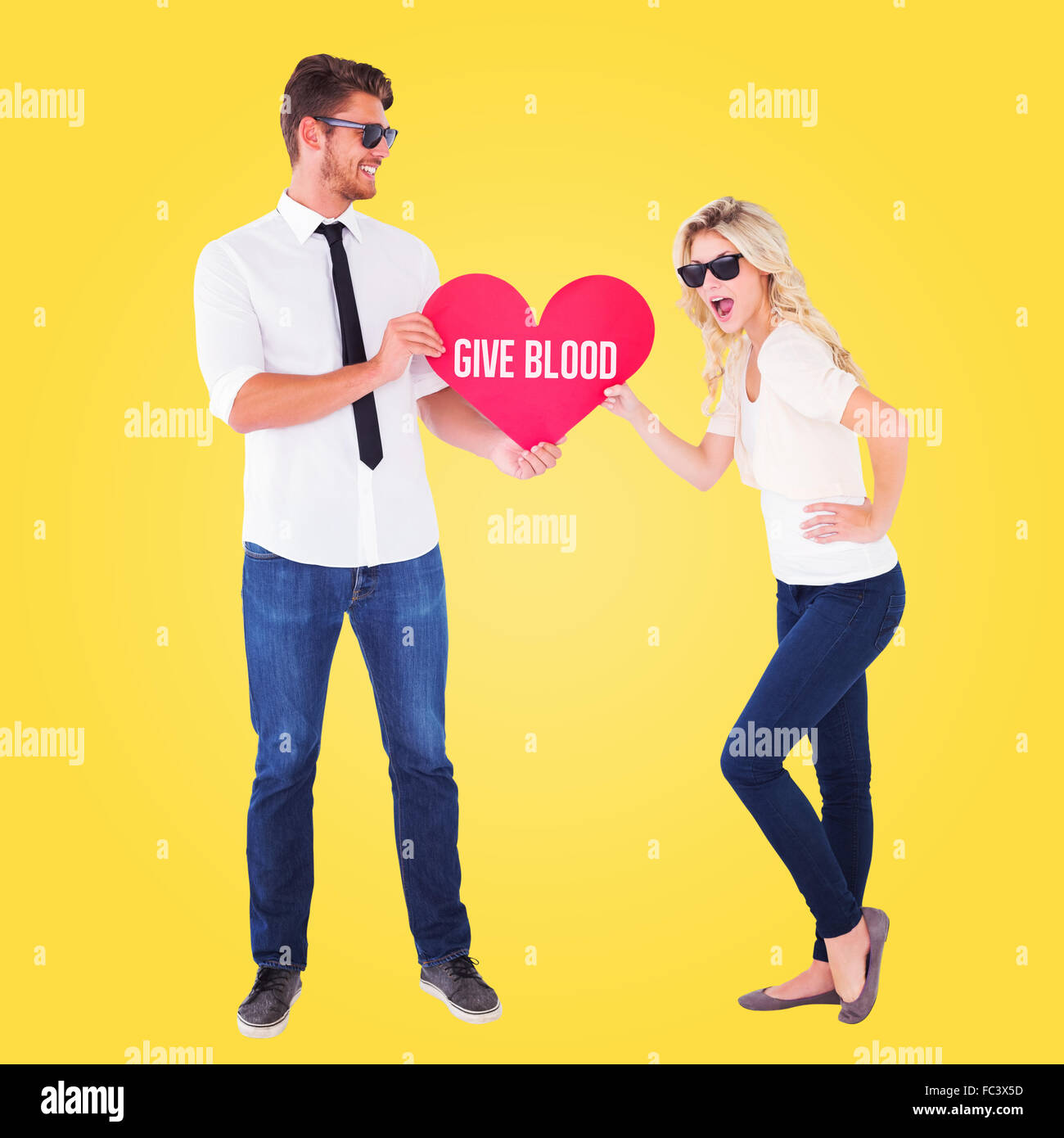 Composite image of cool young couple holding red heart Stock Photo - Alamy