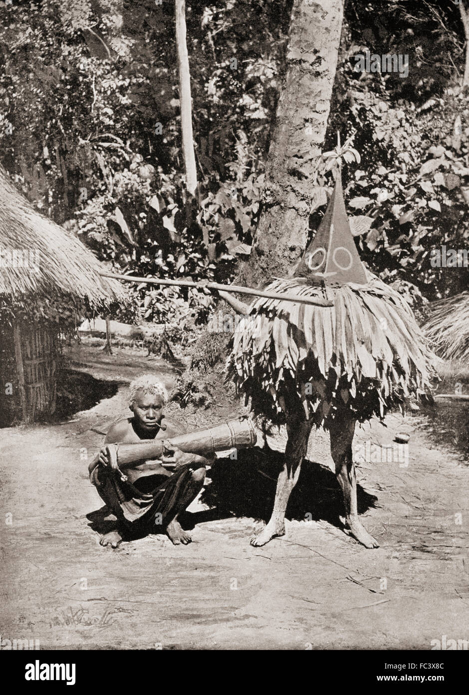 A masked dancer of a Duk-Duk secret society.  The Duk-Duk was embedded in the beliefs of the Tolai peoples in the Rabaul area of New Britain, the largest island in the Bismarck Archipelago of Papua New Guinea.  Only men were allowed to join. From a 19th century photograph. Stock Photo