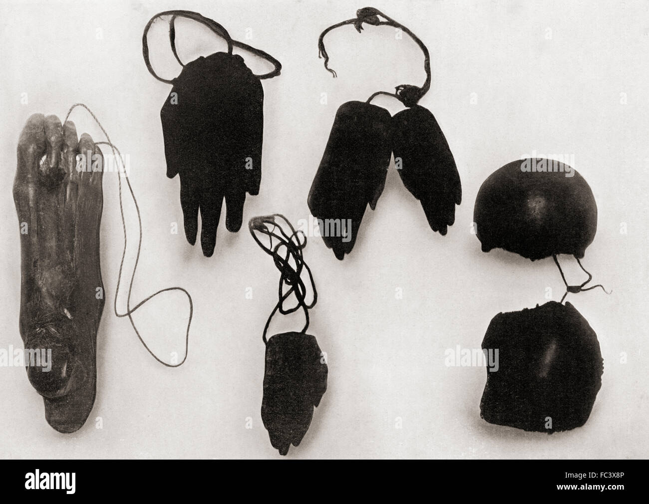 Human ornaments including a dried and smoked foot, hands and portions of a skull of a New Guinea man, worn by grieving relatives of the deceased as a memorial.  After a 19th century photograph. Stock Photo