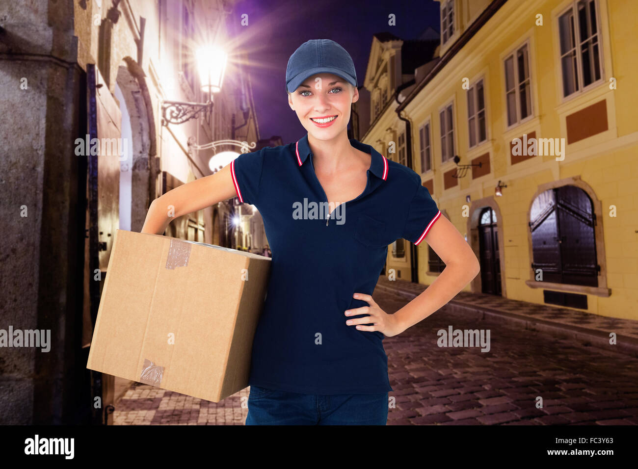 Composite image of happy delivery woman holding cardboard box Stock Photo