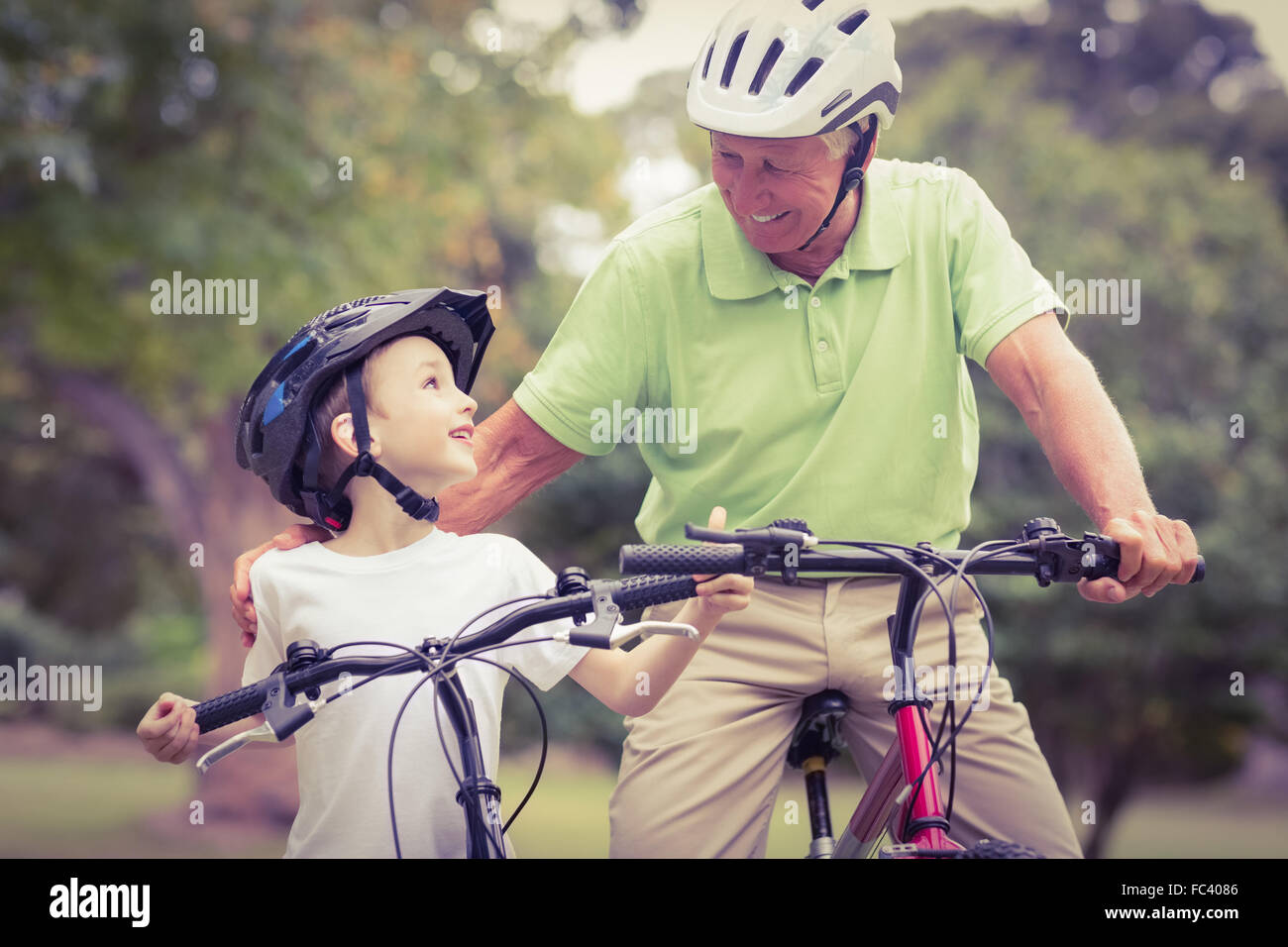 Happy grandfather with his granddaughter on their bike Stock Photo