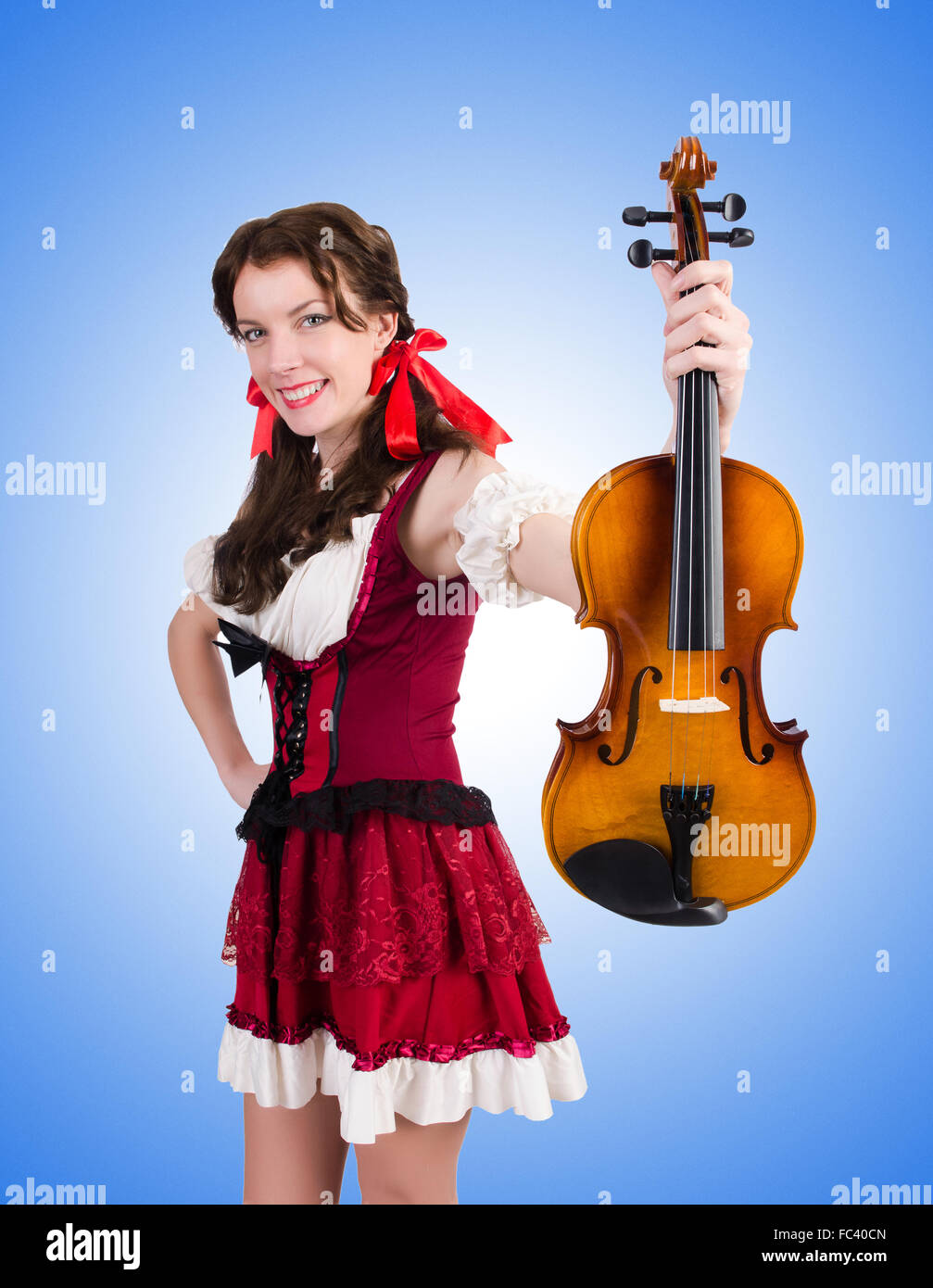 Young woman playing violin against gradient Stock Photo - Alamy