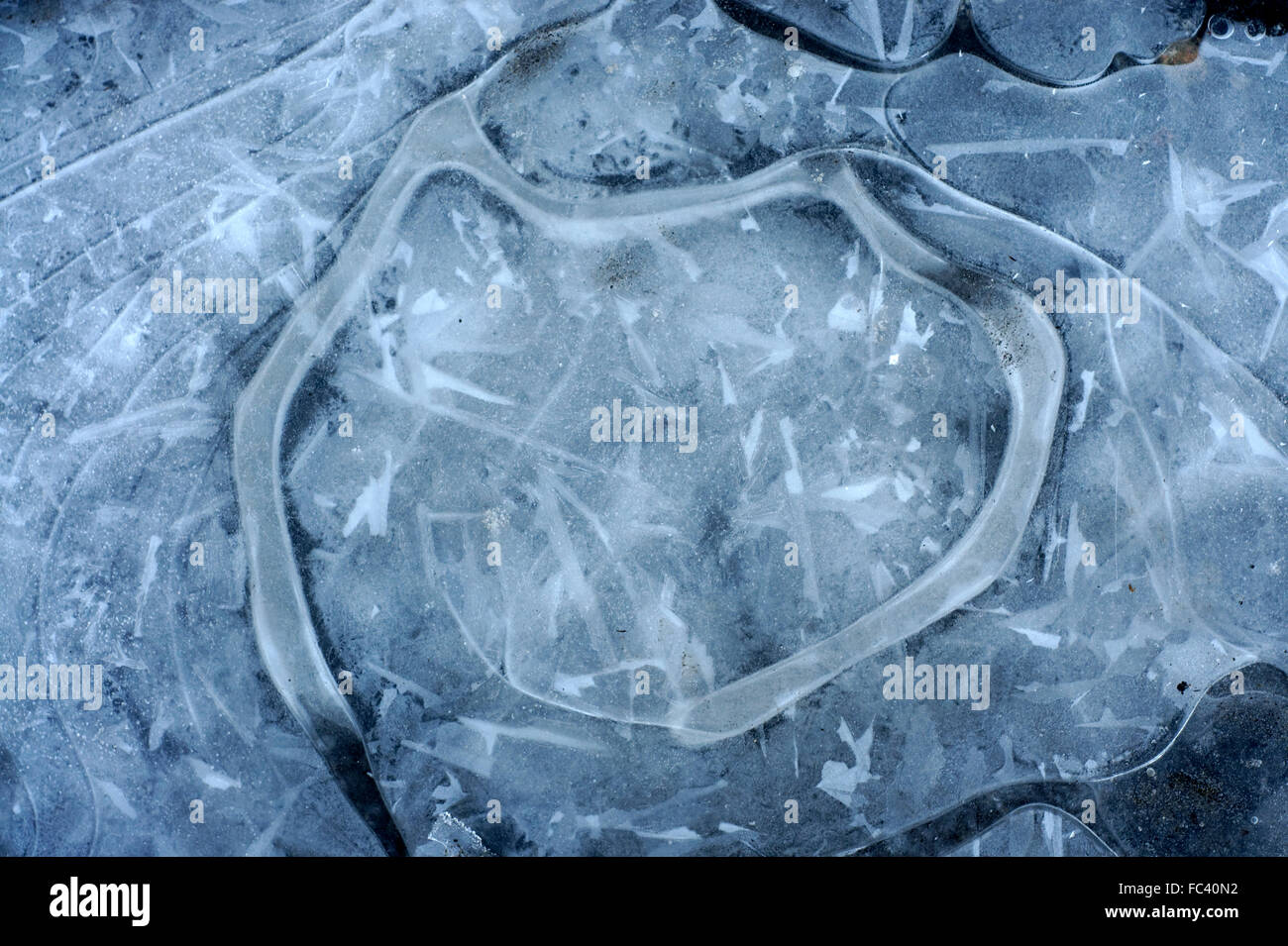 Ice patterns in a frozen puddle of water Stock Photo