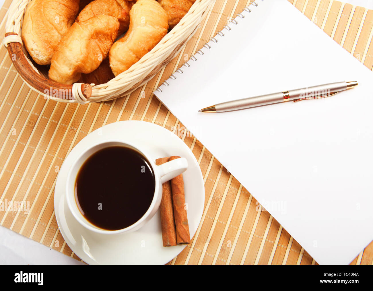 Breakfast coffee and croissants on a light background with a notebook ...