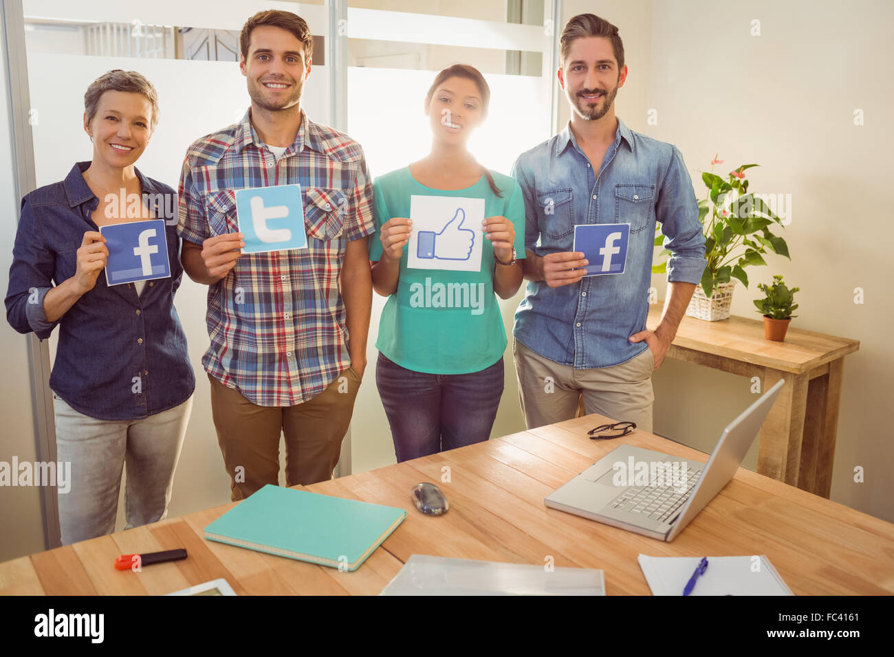Colleagues holding sign from famous social networks Stock Photo - Alamy