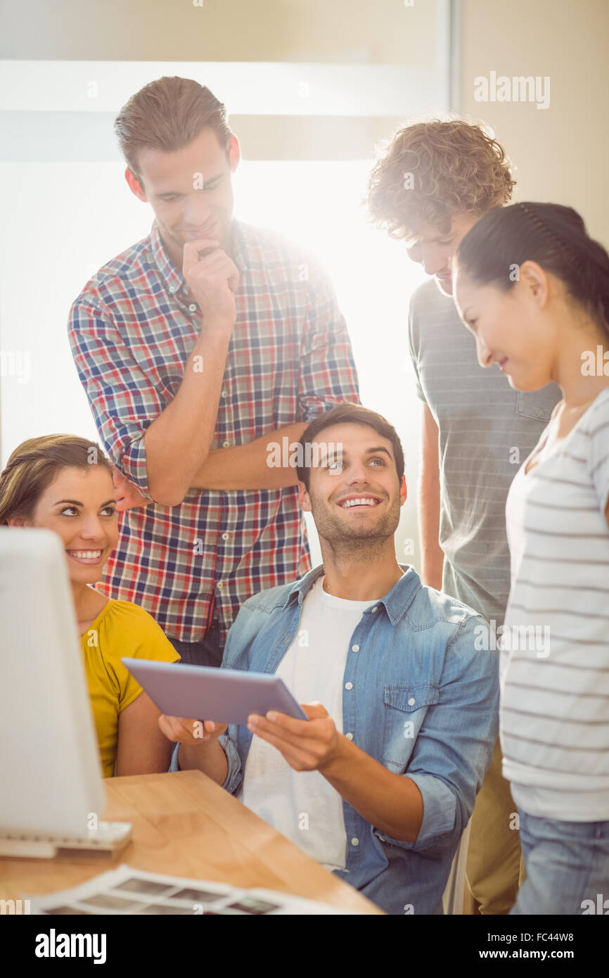 Creative business team gathered around a tablet Stock Photo - Alamy