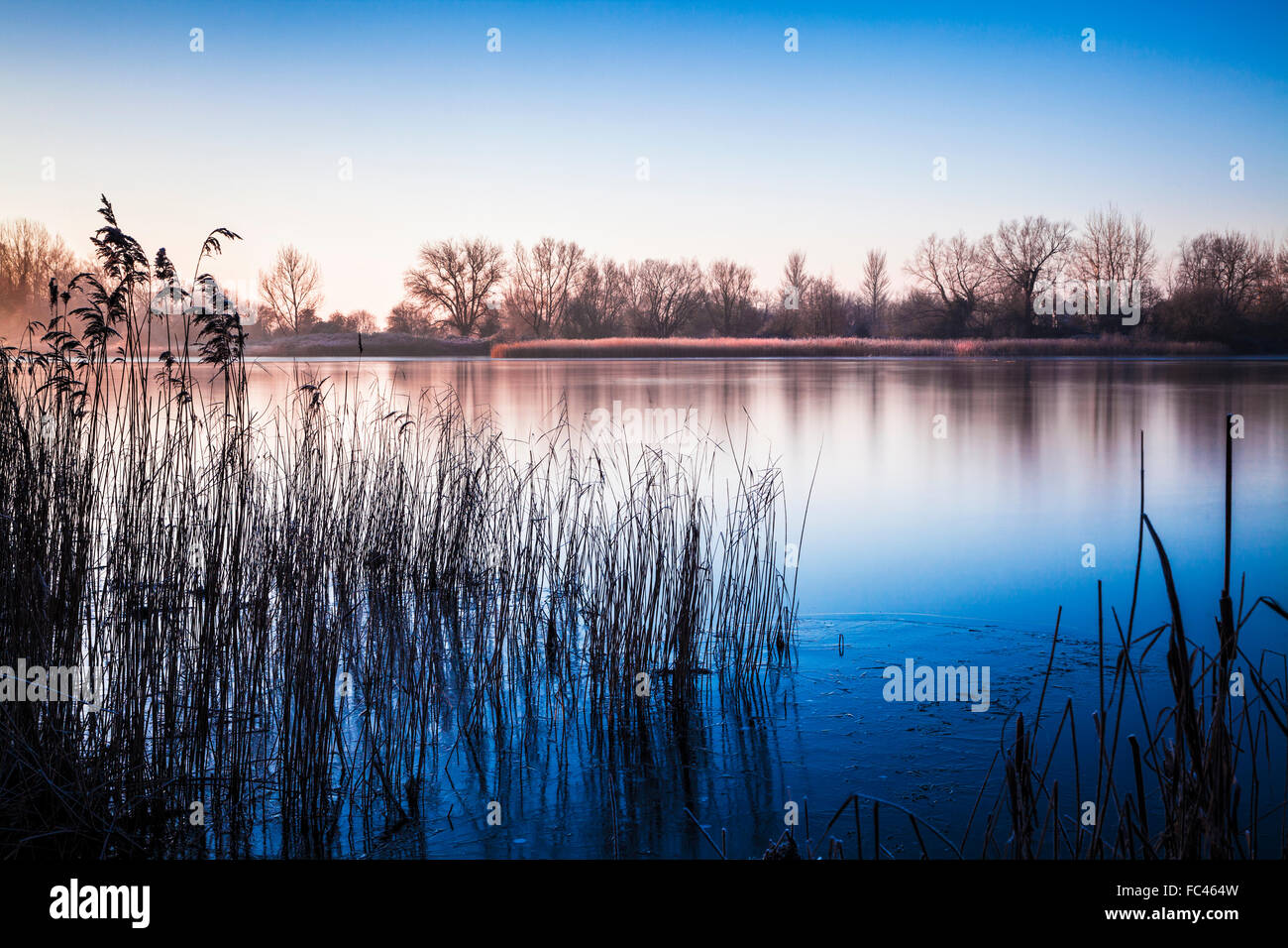 A winter sunrise over one of the lakes at Cotswold Water Park Stock Photo
