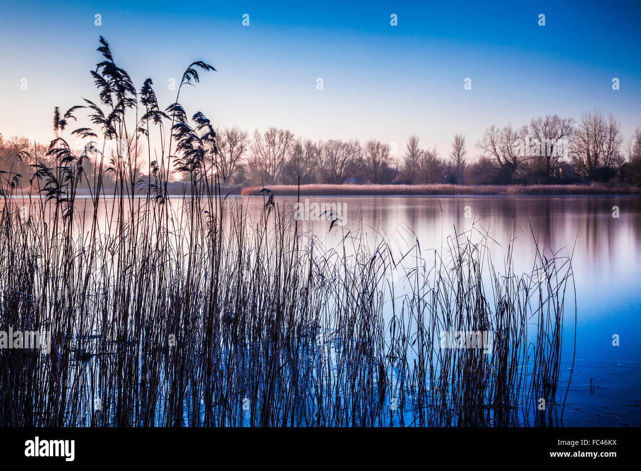 A winter sunrise over one of the lakes at Cotswold Water Park Stock Photo