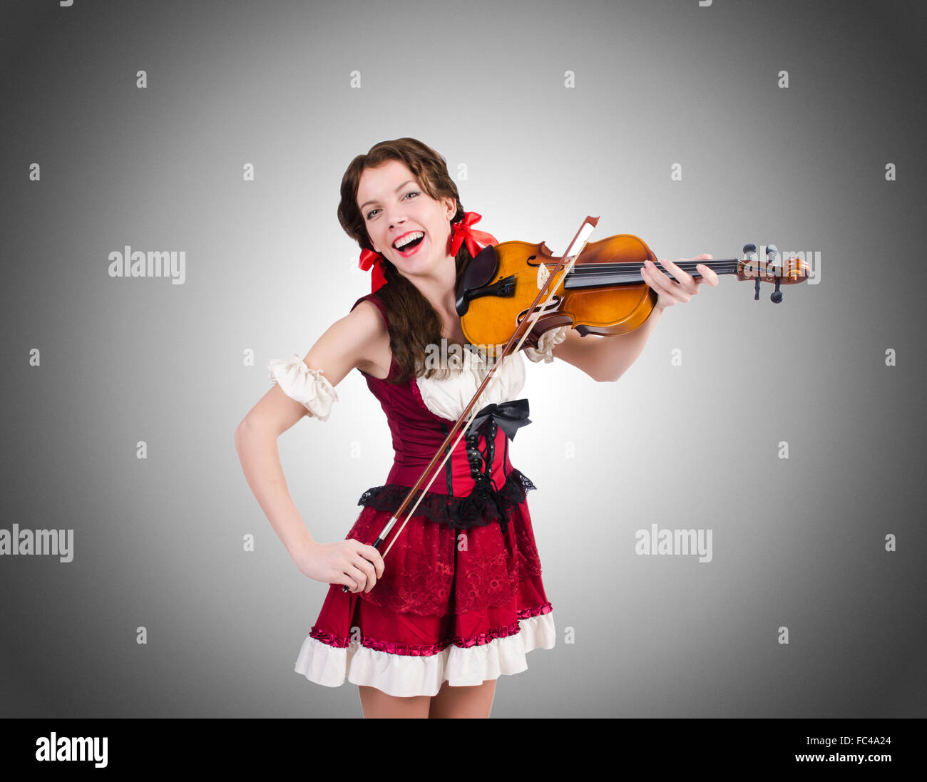 Young woman playing violin against gradient Stock Photo - Alamy