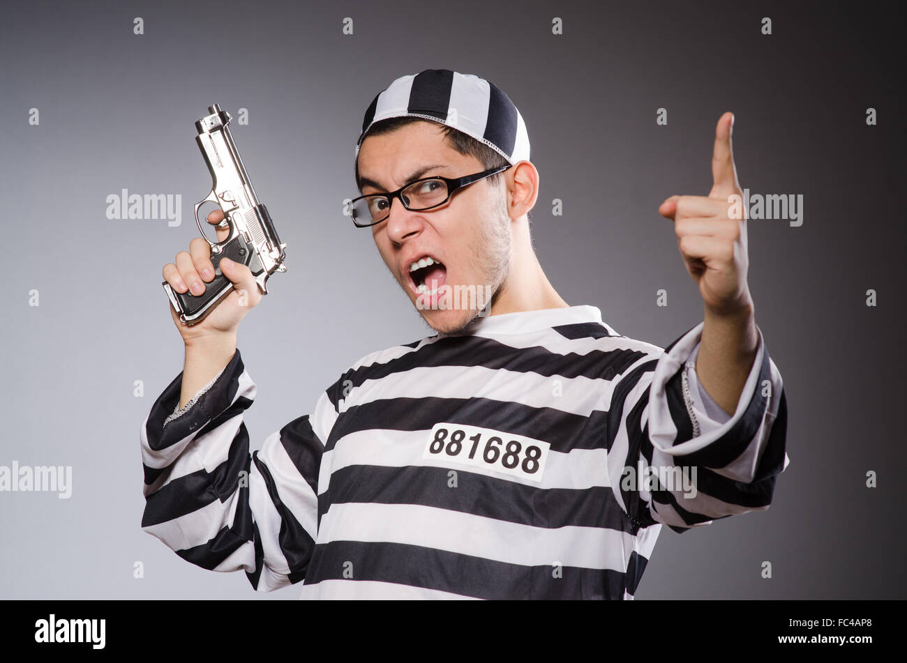 Funny prisoner with firearm isolated on gray Stock Photo Alamy
