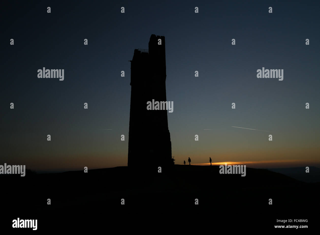 Huddersfield, West Yorks, UK. 20th January, 2016. People watch the sun set over Huddersfield in West Yorkshire, UK, next to the Victoria Tower atop Castle Hill. The UK saw temperatures plummet to below -12 degrees for the second day in a row despite the bright sunny weather across much of the country. Credit:  Ian Hinchliffe/Alamy Live News Stock Photo