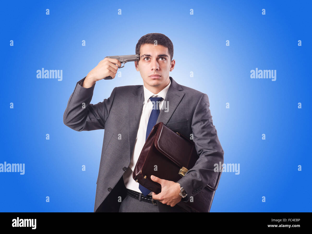 Businessman thinking of suicide against gradient Stock Photo