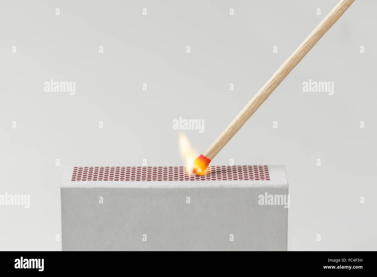 A Match being lit with the striking surface of a matchbox Stock Photo