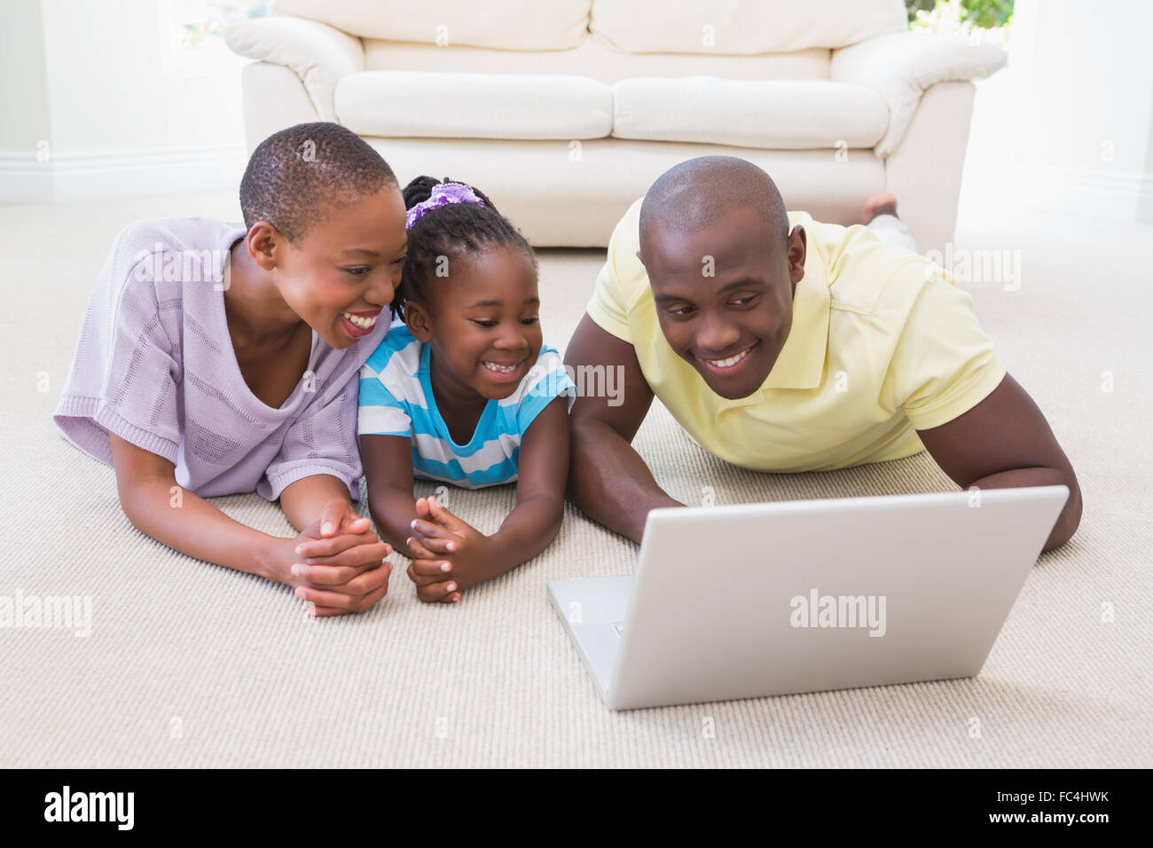 Happy smiling couple using laptop with their daughter Stock Photo - Alamy