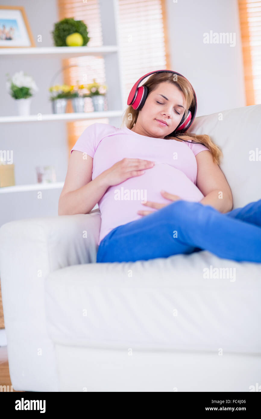 Pregnant woman listening music and touching her belly Stock Photo - Alamy