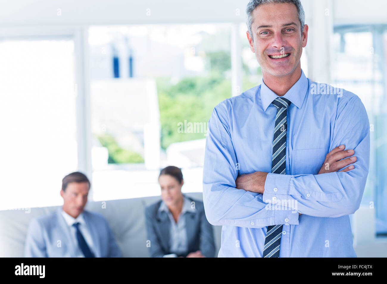 Businessman looking at camera with his colleagues behind him Stock ...