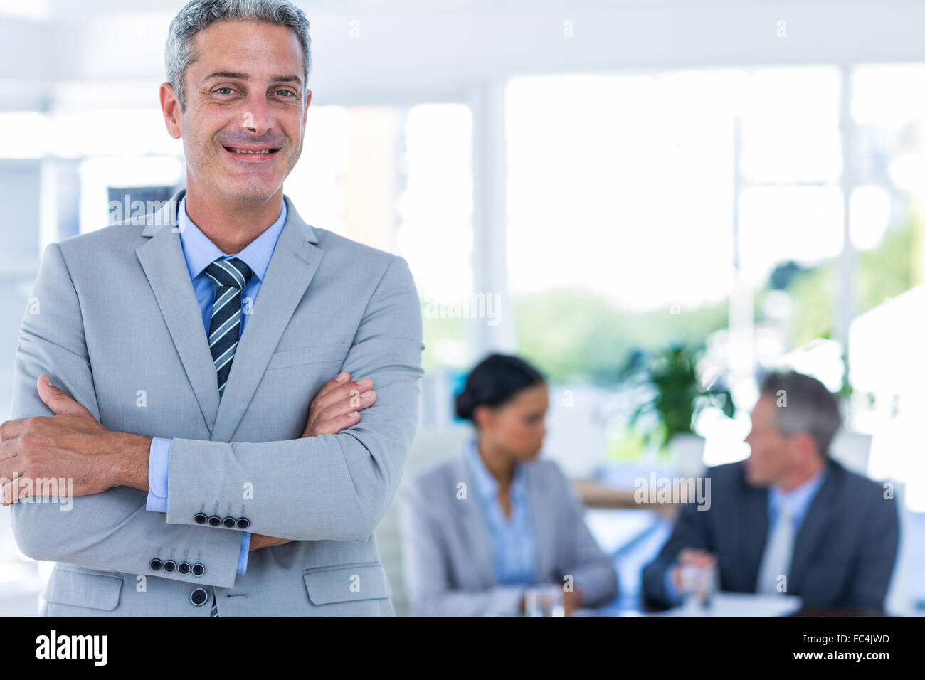 Businessman looking at camera with his colleagues behind him Stock ...
