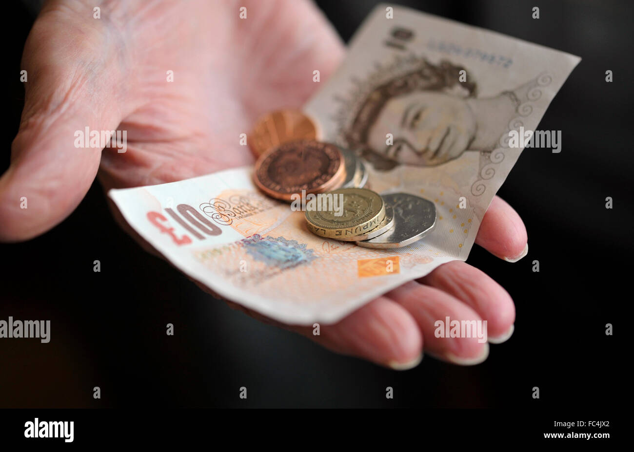 Money in the hand of an old age pensioner. Stock Photo