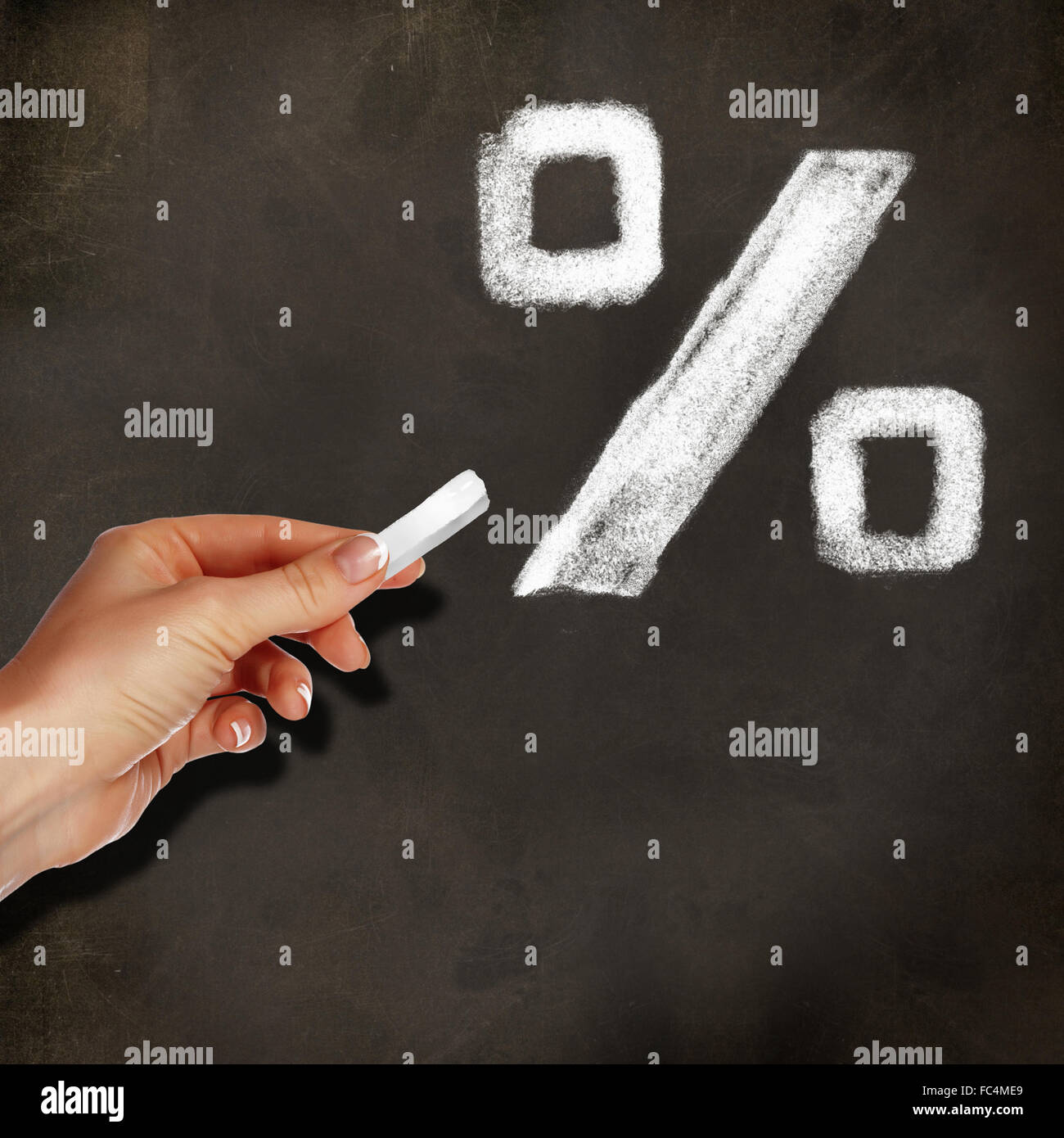 School blackboard and hand with chalk writing percentage symbol on it Stock Photo