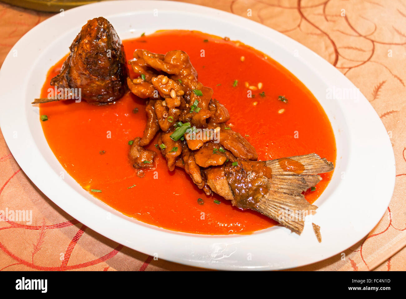 West Lake carp (a kind of white fish) in a sweet and sour red sauce. Served as part of a Chinese meal. Stock Photo