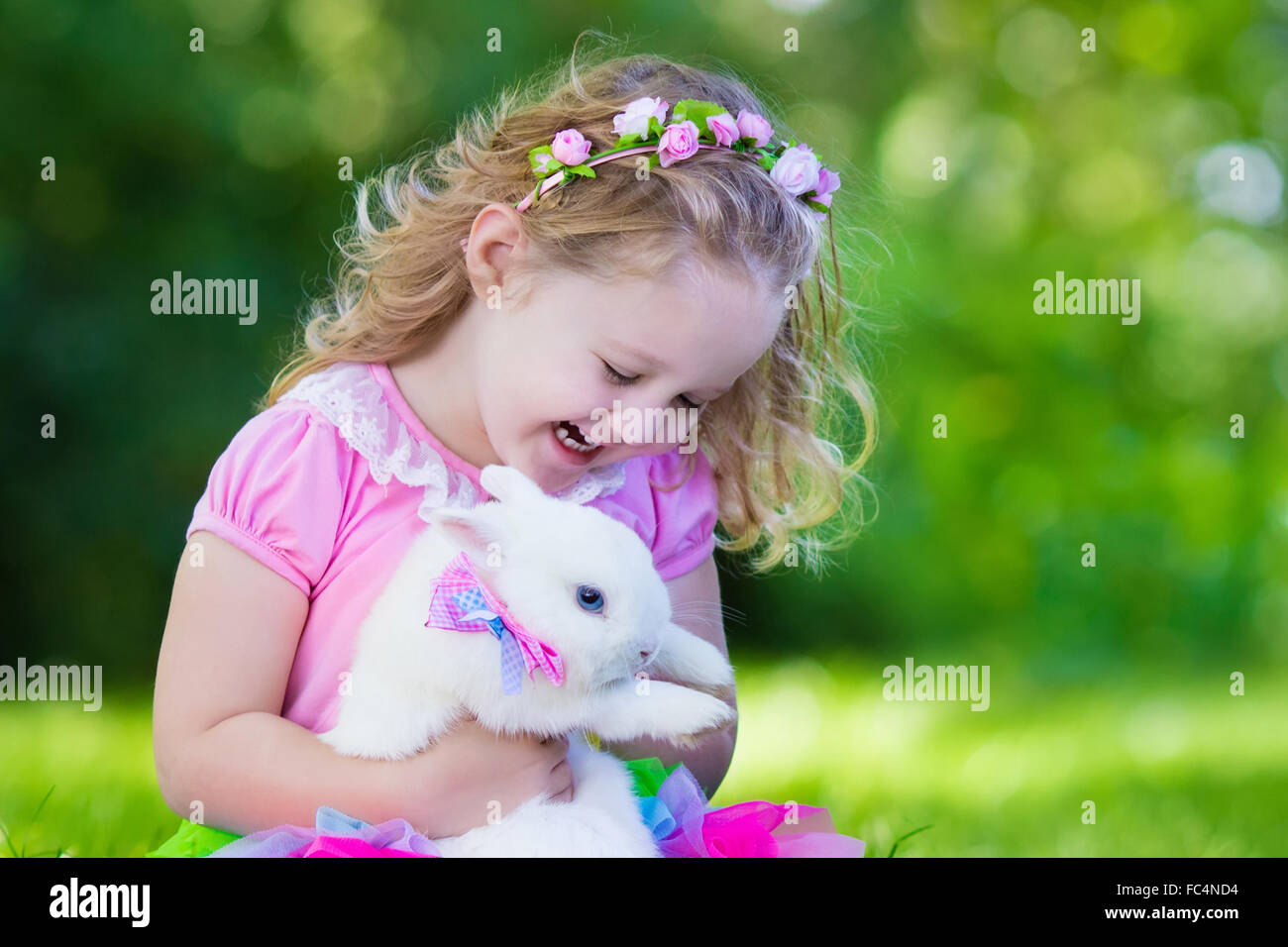 Children play with real rabbit. Brother and sister at Easter egg hunt