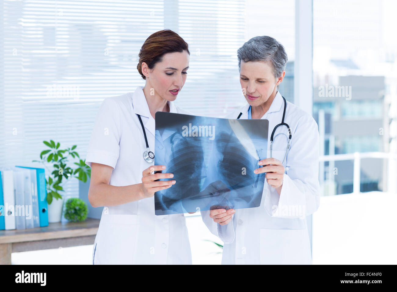 Concentrated medical colleagues examining x-ray together Stock Photo ...