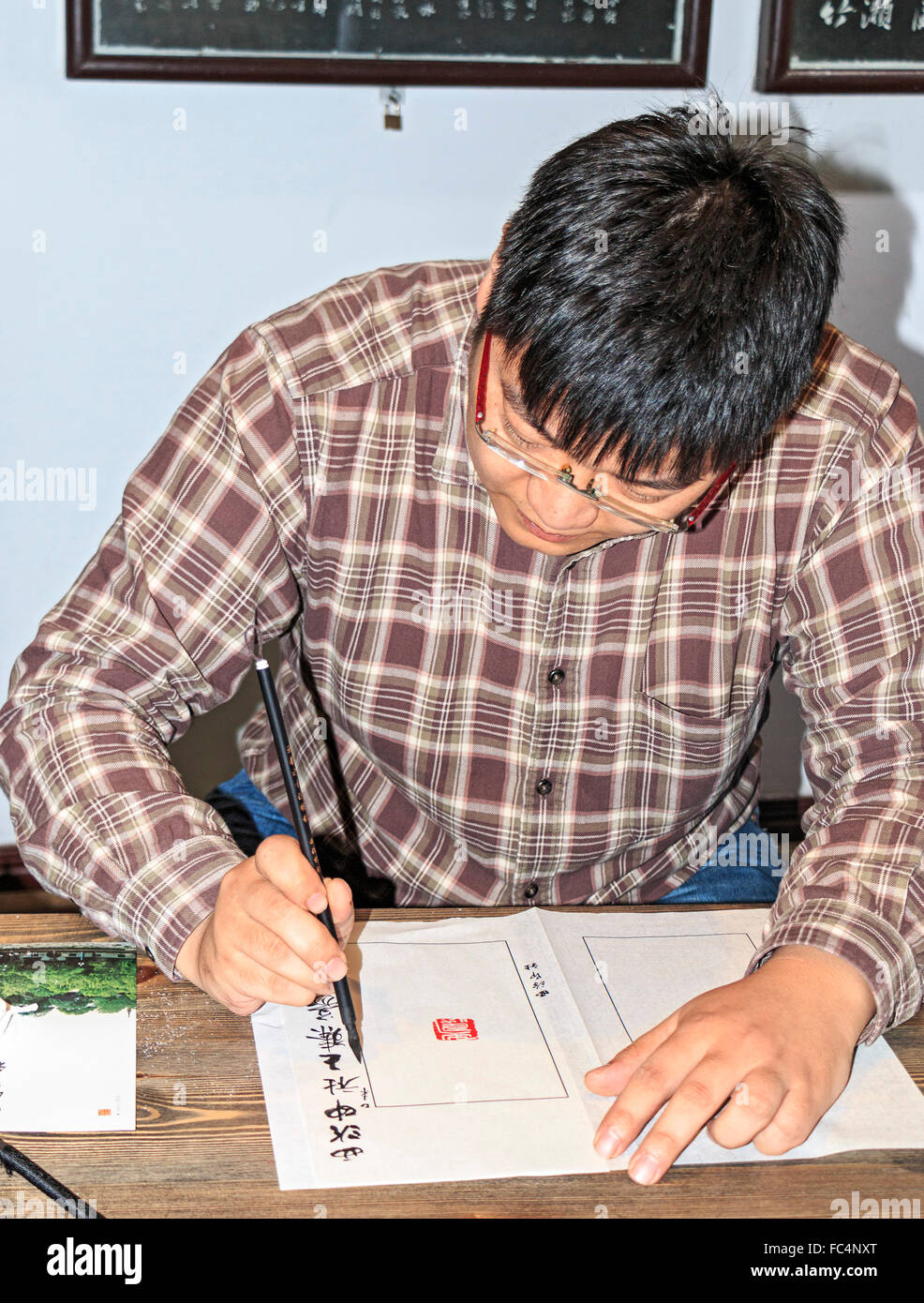 Wang Zhen, a master engraver, shows students how to carve a seal or chop at Xiling Seal Engraver's society in Hangzhou, China. Stock Photo