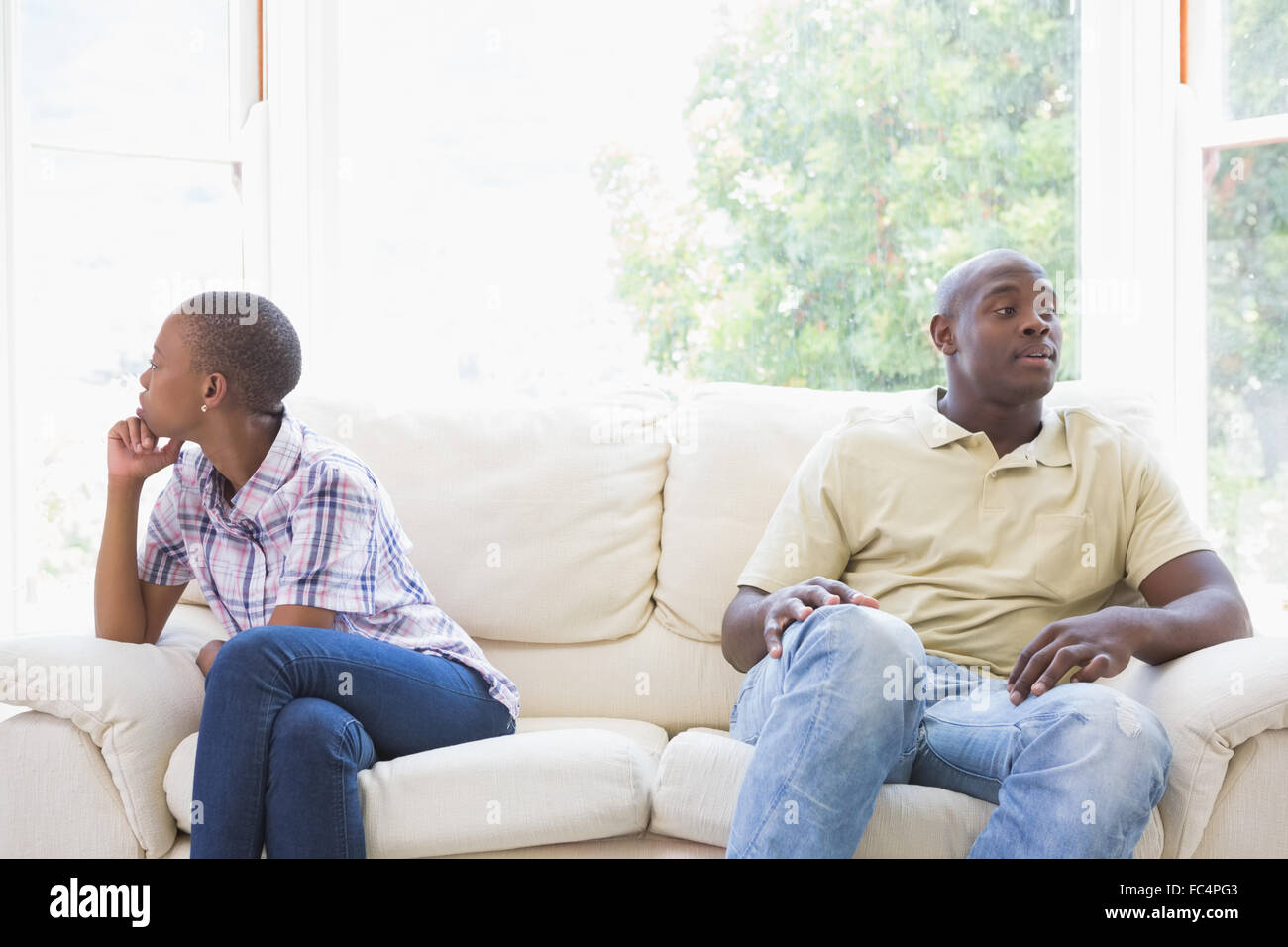 A dispute between a couple sitting on the couch Stock Photo - Alamy