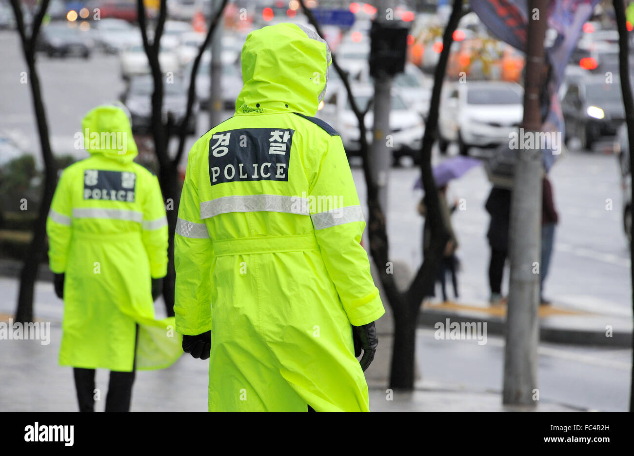 Police officers in the rain at a street in Seoul, South Korea Stock Photo