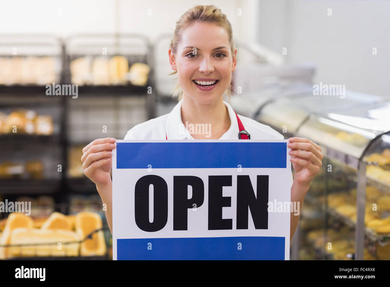 Portrait of a smiling blonde woman holding a sign Stock Photo - Alamy