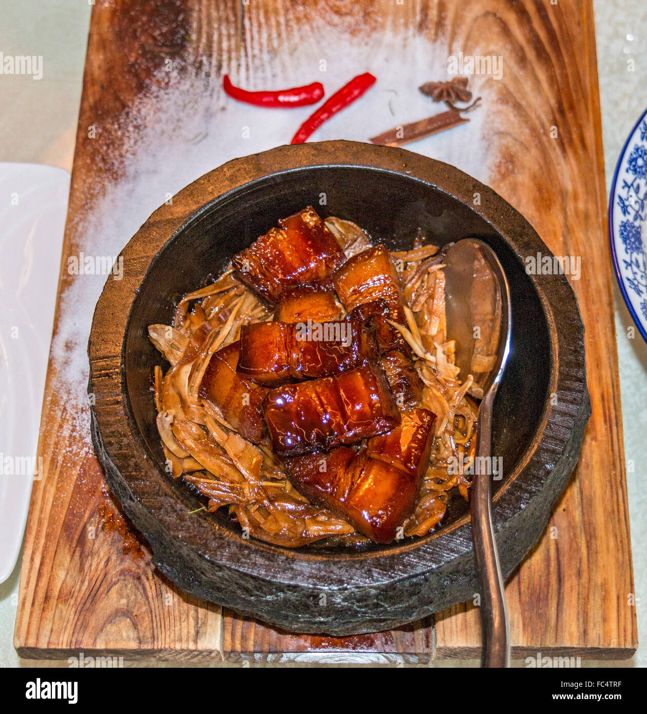 Pork belly braised in dark soy sauce and served in clay pot. Stock Photo