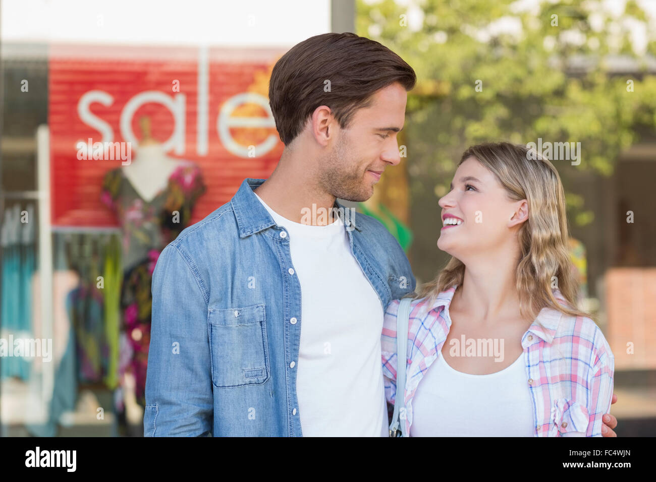 happy couple standing in front of a SALE sign Stock Photo - Alamy