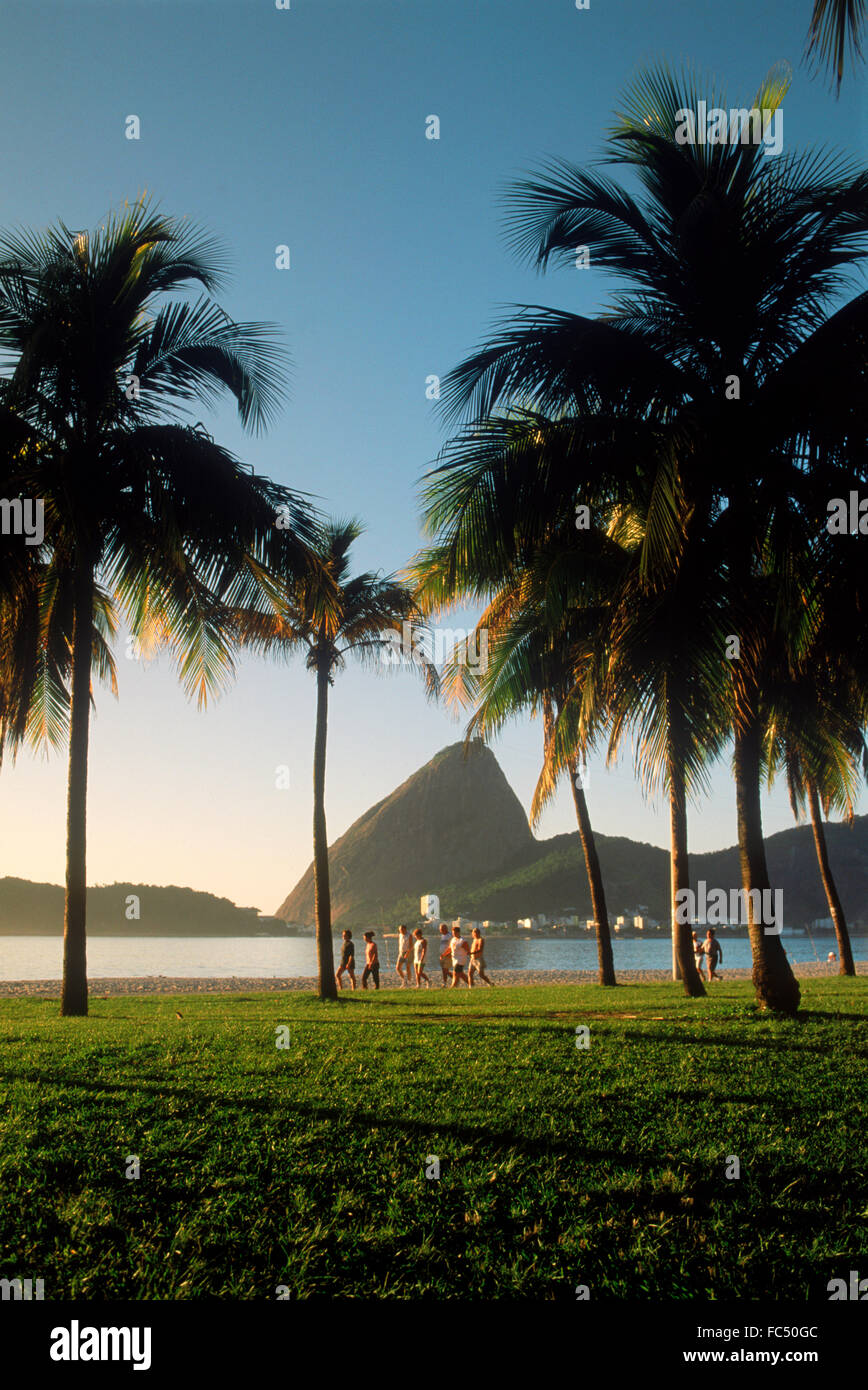 People taking morning jog and walk along Flamengo Beach near Sugar Loaf at sunrise in Rio de Janeiro Brazil Stock Photo