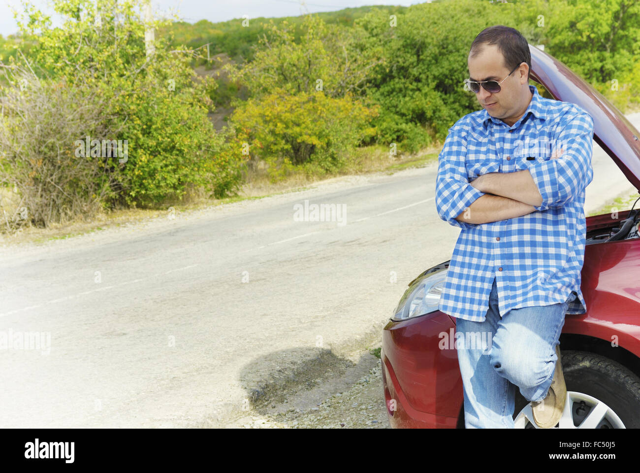 Adult man is standing near his broken car Stock Photo