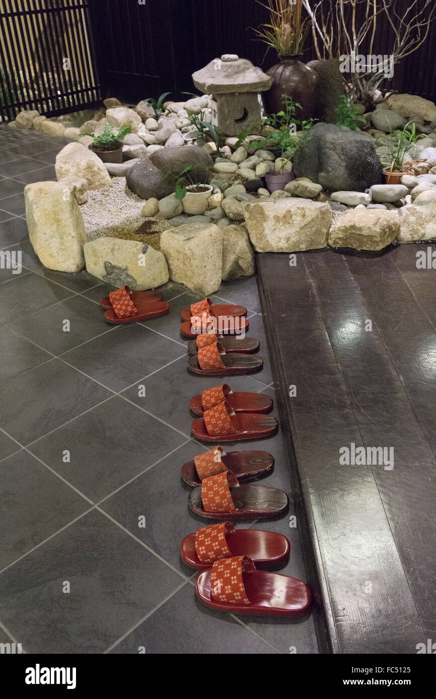 Traditional entry in a Japanese Roykan with rock garden and slippers Stock Photo