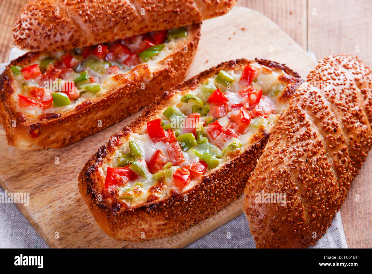 baked baguette stuffed with vegetables and cheese Stock Photo
