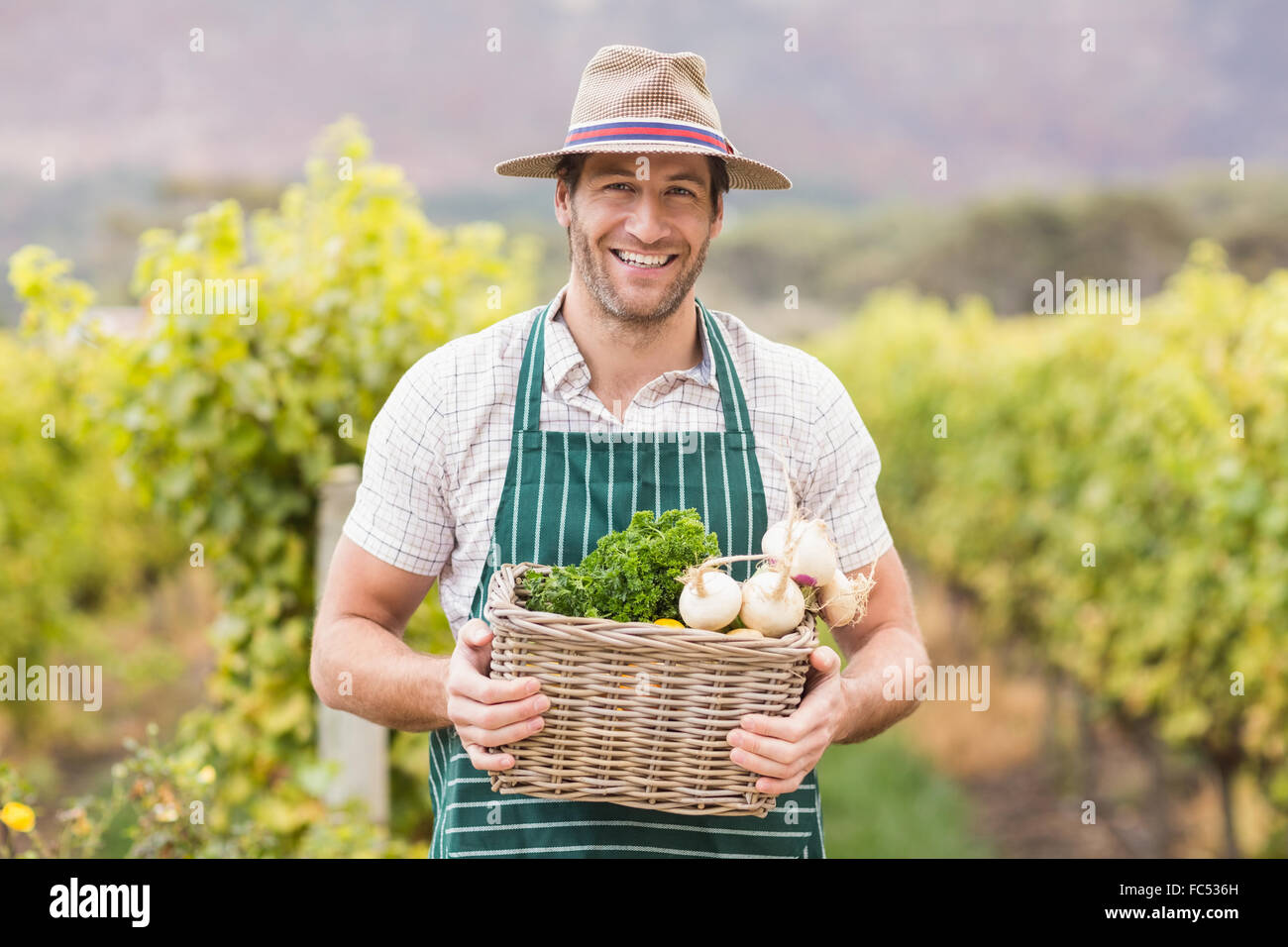 Young happy farmer holding a basket of vegetables Stock Photo - Alamy