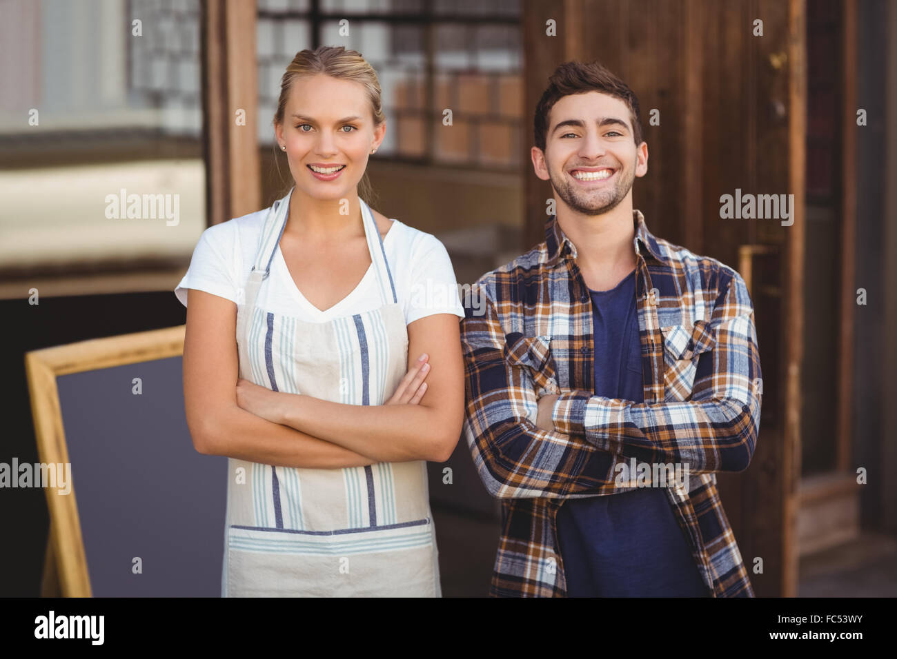 Smiling waitress and her colleague with arms crossed Stock Photo - Alamy