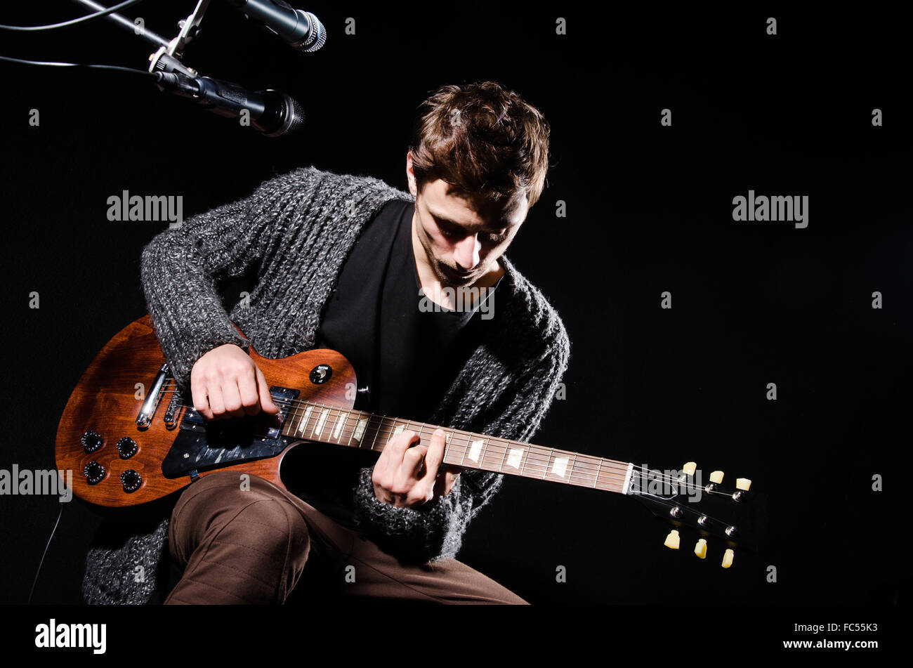 Man playing guitar in dark room Stock Photo - Alamy