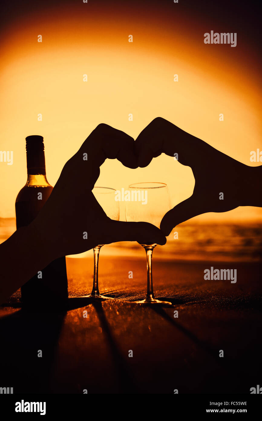 Composite image of couple making heart shape with hands Stock Photo - Alamy