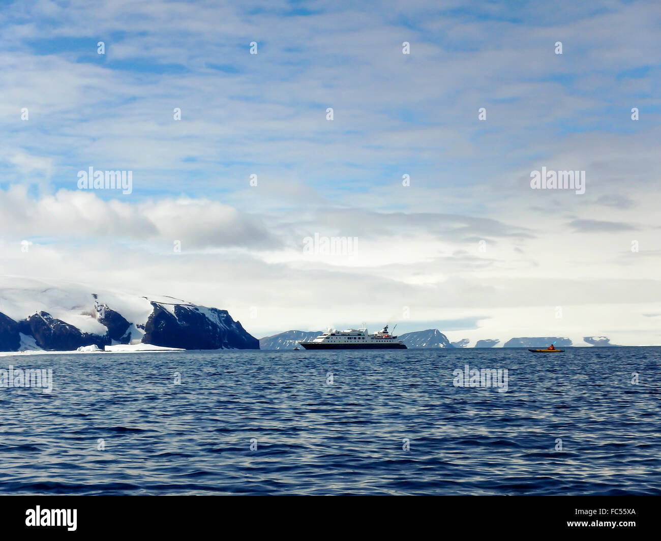 Cruise ship in Gustaf Sound in the Wheddle Sea of Antarctica with kayakers. Stock Photo