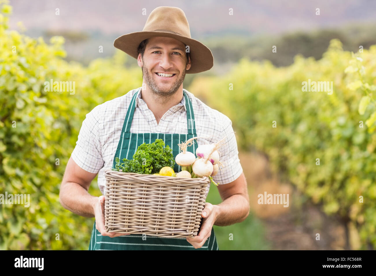 Young happy farmer holding a basket of vegetables Stock Photo - Alamy