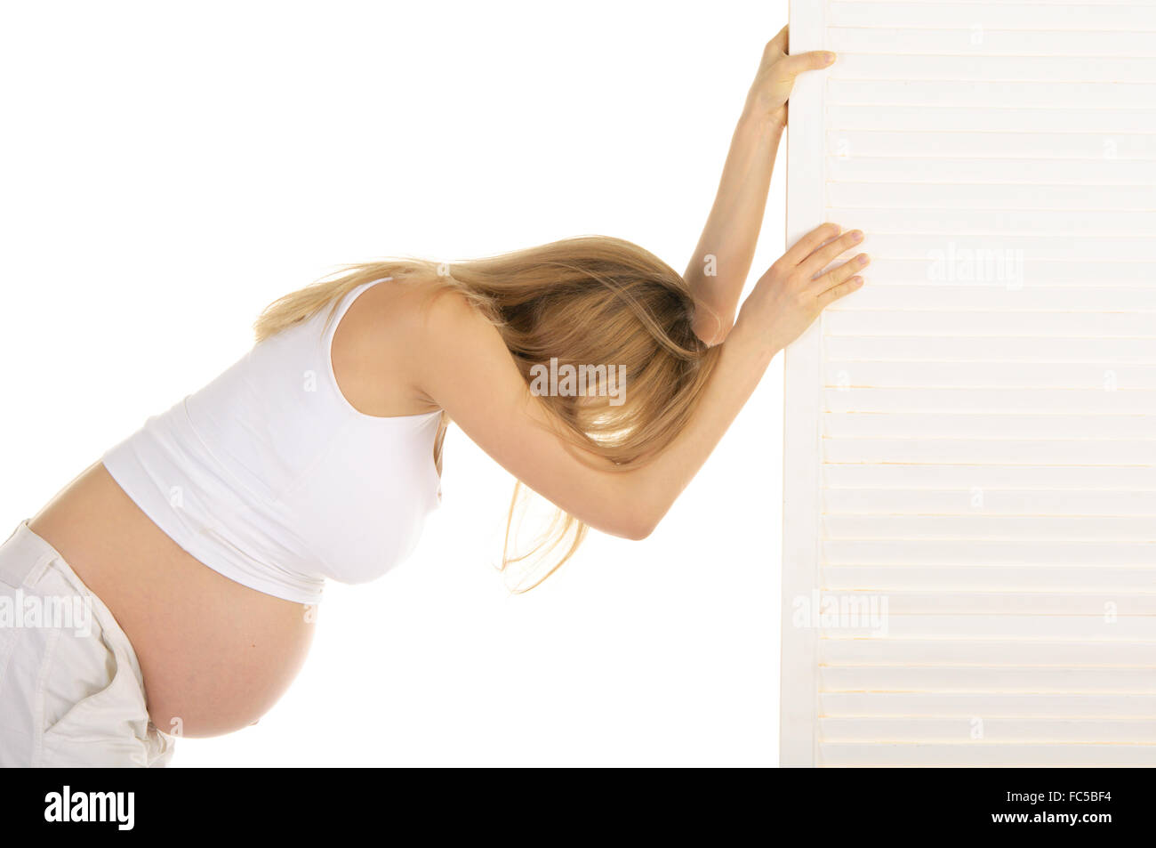 tired pregnant woman leaned on the door Stock Photo